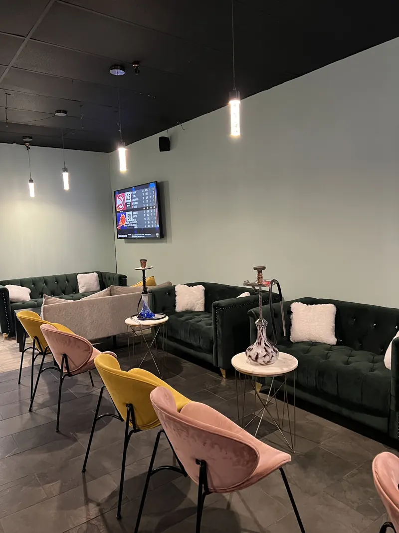 Green velvet sofas and pink velvet chairs in the front lounge