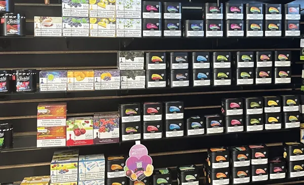 A wall of shisha tobacco tins and boxes, mostly Al Fakher, plus Serbetli, Mazaya and Afzal